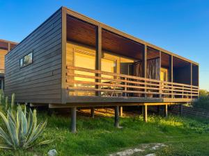 una casa con una gran terraza sobre el césped en Kahuna Surflodge, en Pichilemu