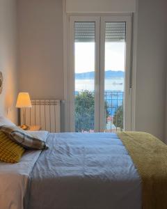 a bedroom with a bed with a view of the ocean at Apartamento Miracies in Vigo