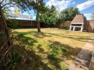 a yard with a tree and a building at Un lugar perfecto in Juana Koslay 