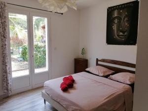 een slaapkamer met een bed met een rode teddybeer erop bij Les Dourets in Saint Antonin du Var +10 foto's