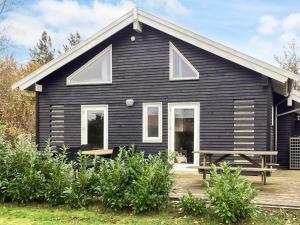 Bøtø Byにある4 star holiday home in Væggerløseの前にベンチがある黒い家