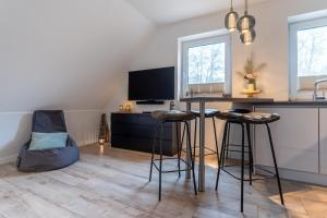 a kitchen with a desk with stools and a television at Ferienwohnung in St Peter-Ording in St. Peter-Ording