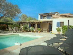 a house with a swimming pool with lawn chairs at Villa Muguet in Bagnols-en-Forêt