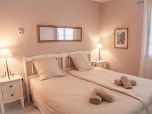 a bedroom with a large white bed with two lamps at Villa Muguet in Bagnols-en-Forêt +40 photos