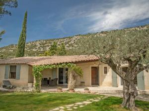 a house with a tree in the yard at Le Mas Romarin in Beaumes-de-Venise