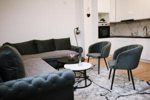 a living room with a couch and two chairs and a table at Modern Apartment MOMENT in Brčko