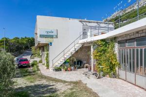 a building with a car parked in front of it at Apartments with parking space Marusici, Omis - 954 in Mimice