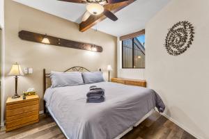 a bedroom with a bed and a ceiling fan at Charming Country Club Condo with Loft & Fireplace in Flagstaff