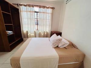 Un dormitorio con una cama grande con ventana. en Apartamento familiar Galapagos, en Puerto Ayora