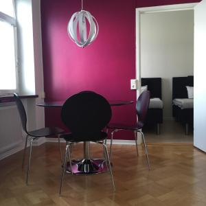 uma sala de jantar com uma parede roxa e cadeiras em Västerviks Citylägenhet em Västervik