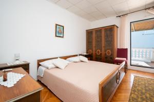 ein Schlafzimmer mit Bett, Schreibtisch und Fenster in der Unterkunft Apartments by the sea Zaglav, Dugi otok - 23204 in Sali