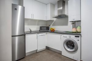 a kitchen with a refrigerator and a washing machine at Slow Suites Luchana in Madrid