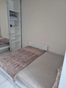 a bed with a blanket on it in a room at Kitnet Balneário Flamingo in Matinhos +35 photos