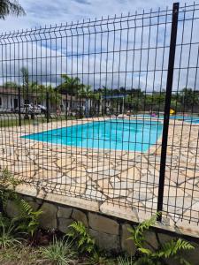 a fence in front of a swimming pool at Kitnet Balneário Flamingo in Matinhos