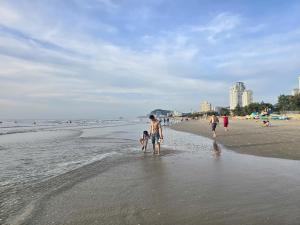 a group of people walking on the beach at ZoZo House - Homestay Bai Sau - bien Vung Tau in Vung Tau