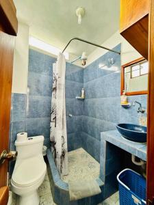 un baño con inodoro y lavabo en Suite con acceso a terraza vista a la Bahia, en Puerto Ayora