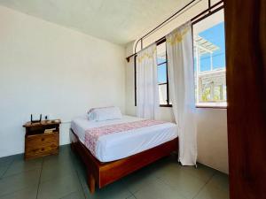 Un dormitorio con una cama y una cómoda y una ventana. en Suite con acceso a terraza vista a la Bahia, en Puerto Ayora