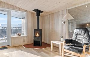 a living room with a fireplace and a chair at Gorgeous Home In Thisted With Sauna in Klitmøller