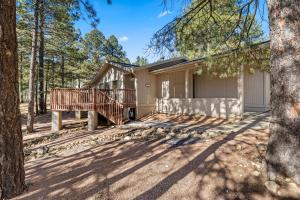 ein Haus im Wald mit einer Terrasse in der Unterkunft Charming 3BD Continental Country Club Retreat in Flagstaff in Flagstaff