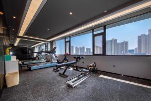 a gym with cardio equipment in a building with windows at Atour Hotel Huainan Railway Station Commercial and Cultural Square in Huainan