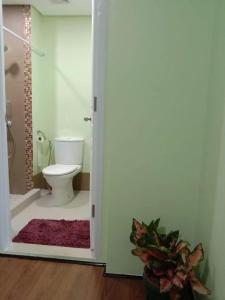 a bathroom with a toilet and a shower and a door at 1BR Condo w Pool & Balcony Near Robinson Place - F&M Homes - Sitio Uno Residences, Pueblo de Panay in Roxas City +13 photos