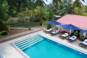 an overhead view of a swimming pool with chairs and umbrellas at Sky and Sand Guesthouse in Beruwala