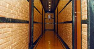 un couloir vide avec un mur en briques et un panier de basket-ball dans l'établissement Hotel Hira, à Mumbai