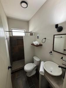 a bathroom with a toilet and a sink and a mirror at Suites 15 Avenida in Tapachula +16 photos