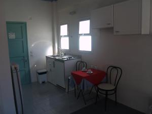 a small kitchen with a red table and chairs at Hotel Cavo Mytikas in Mitika