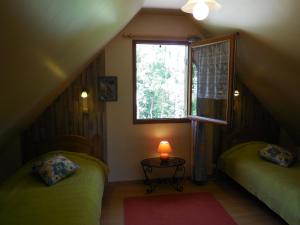 a small room with two beds and a window at Les Gîtes de Galinette in La Bâtie-Vieille
