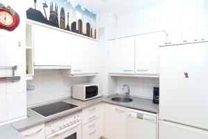 a white kitchen with a sink and a microwave at Apartment Bright Sagrada Familia in Barcelona