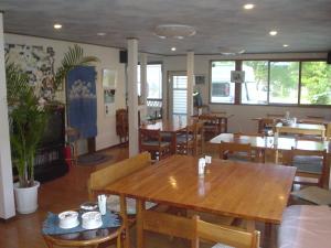 a dining room with wooden tables and chairs at ペンションローザンヌ in Fujikawaguchiko