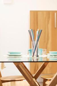 a glass table with chopsticks in a vase on it at TorinoToStay Apartments in Turin