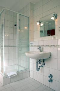 ein Bad mit einem Waschbecken und einer Dusche in der Unterkunft Altstadthotel-Rheine in Rheine