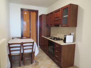 a kitchen with wooden cabinets and a table and a stove at Residence Stella Del Gran Sasso in Colledara