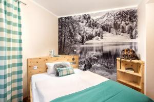 a bedroom with a bed with a painting on the wall at Hotel Wiedemann in Füssen +59 photos