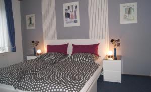 ein Schlafzimmer mit einem schwarzen und weißen Bett mit roten Kissen in der Unterkunft Ferienwohnung Ilsebill in Husum