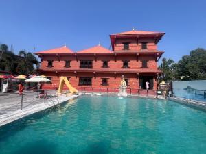 una grande piscina d'acqua di fronte a un edificio di Captains Sky Resort Mahendranagar Museum, Mahendranagar, Nepal a Bahāsi