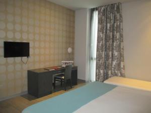 a bedroom with a desk and a bed and a television at Hotel Ciudad De Ponferrada in Ponferrada