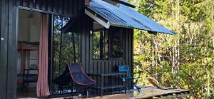 una veranda schermata con due sedie e un tendone di Little Nook at Cozy Porch a Malaybalay Altre 24 foto