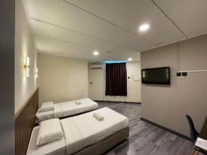 a hospital room with two beds and a flat screen tv at CU Boutique Hotel in Kota Kinabalu +66 photos