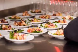 eine Reihe von Tellern mit Lebensmitteln auf einem Tisch in der Unterkunft Hotel Arts in Sankt Leon-Rot