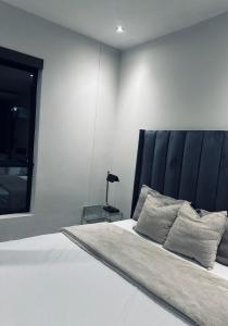 a bedroom with a large bed with a black headboard at Luxury apartment at the paramount in Johannesburg