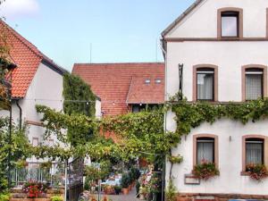 une maison blanche avec du lierre sur son côté dans l'établissement Hotel & Restaurant Weisenheimer Hof, à Weisenheim am Berg