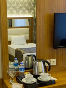 een hotelkamer met een waterkoker en een spiegel bij Carmine Otel in Kırıkkale