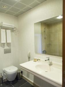 a bathroom with a sink and a toilet and a mirror at Carmine Otel in Kırıkkale