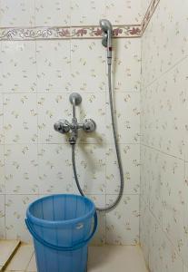 a shower in a bathroom with a bucket at Best Homestay in Puttaparthi