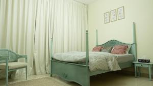 a bedroom with a green bed with pink pillows at Modern Apartment near Burj khalifa in Dubai +26 photos