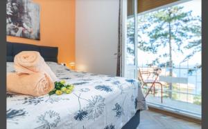 een slaapkamer met een bed met een handdoek en een raam bij Apartment Punta with garage, balcony, garden and sea view in Opatija