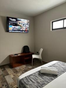 a bedroom with a bed and a desk and a television at Suites 15 Avenida in Tapachula